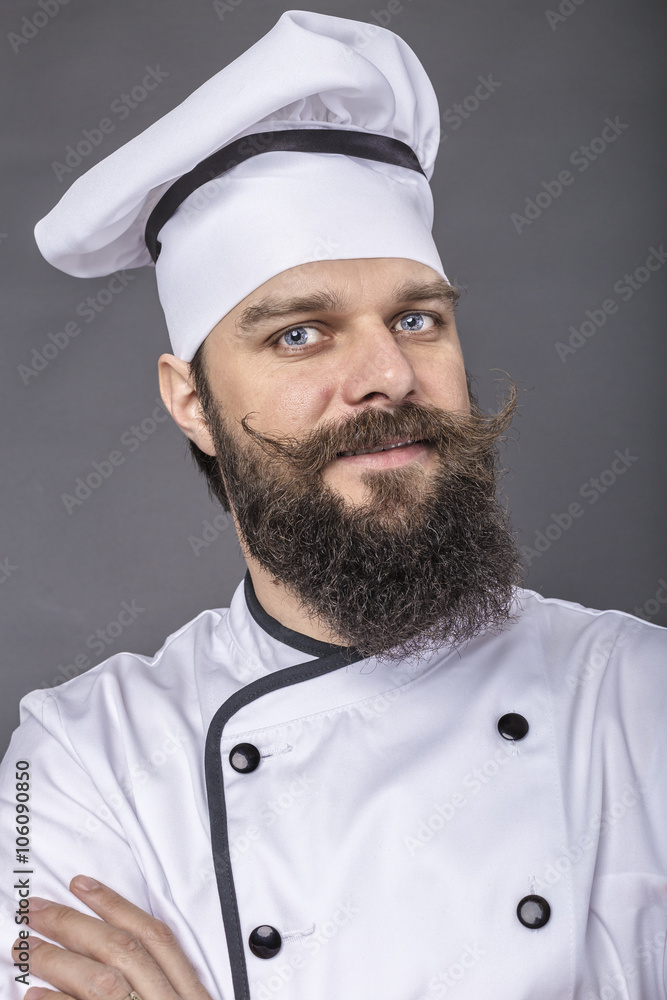 Portrait of a bearded young chef with arms folded