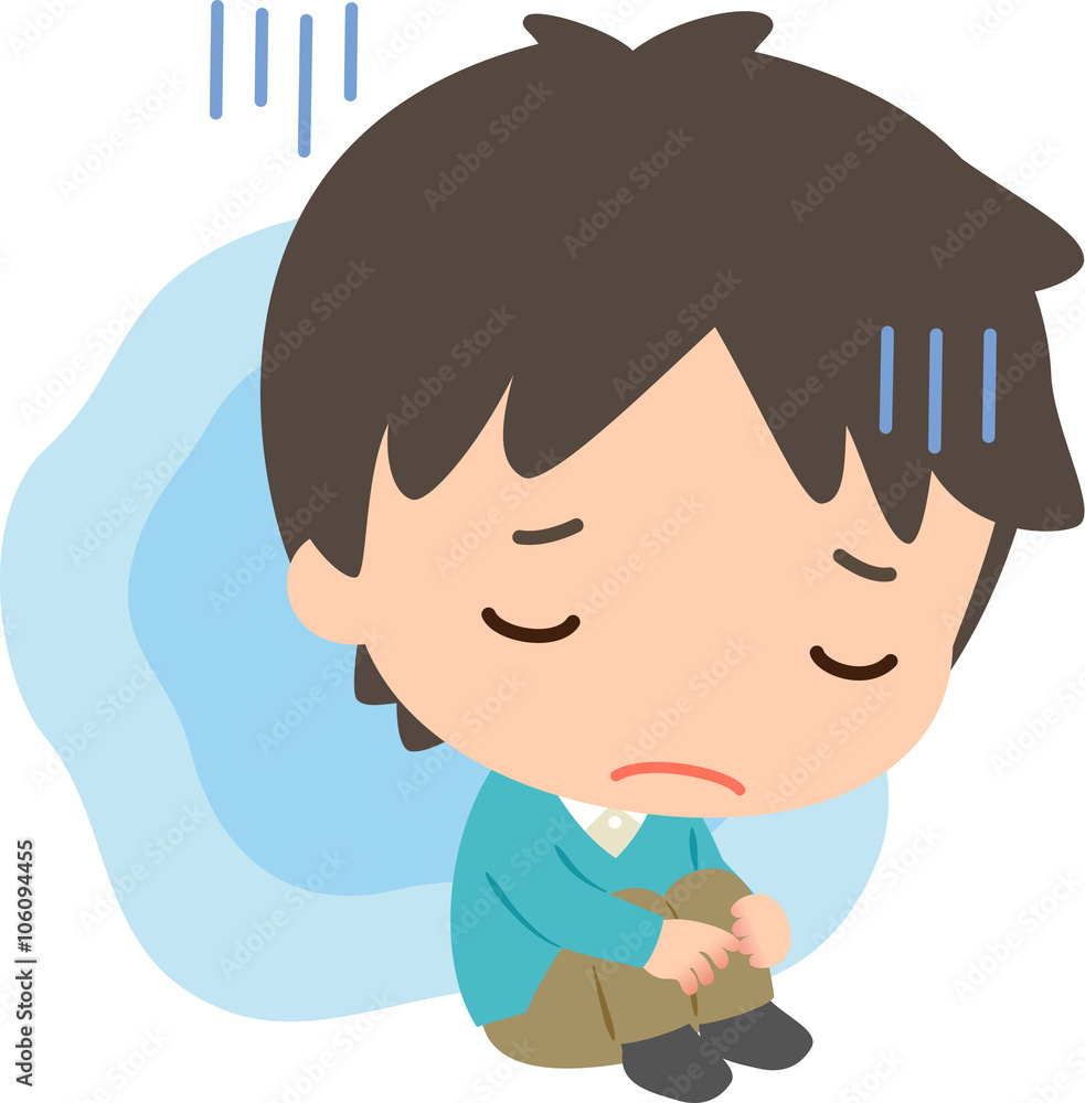 膝を抱えて座る暗い表情の男性