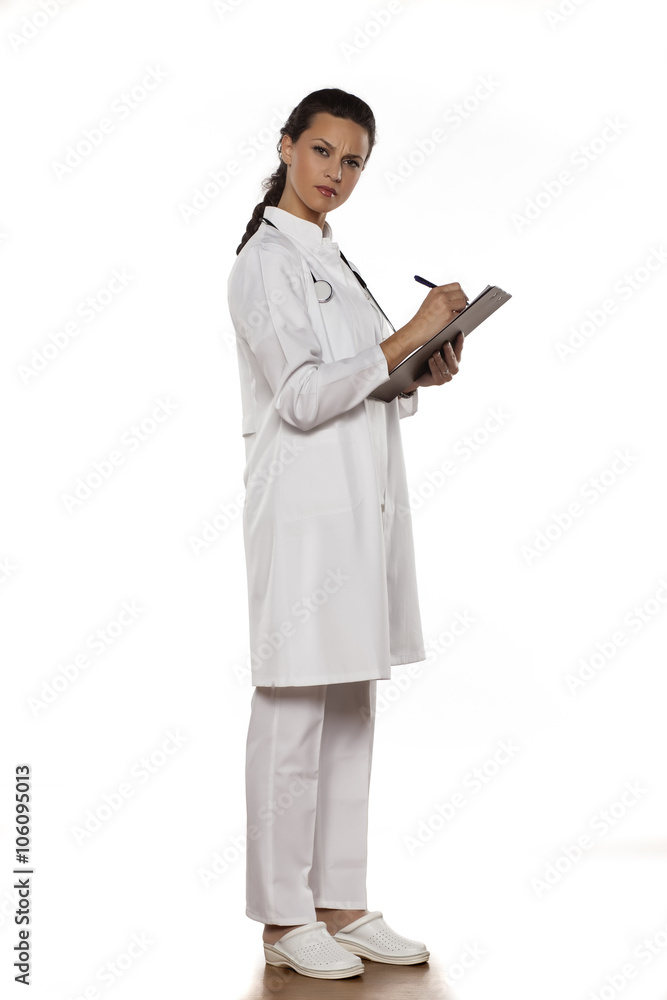 young woman doctor in uniform with clipboard on a white background