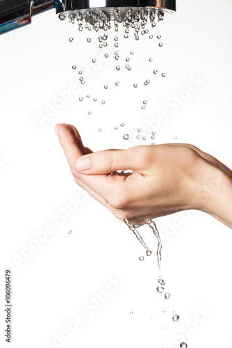 female hands under the falling drops of water