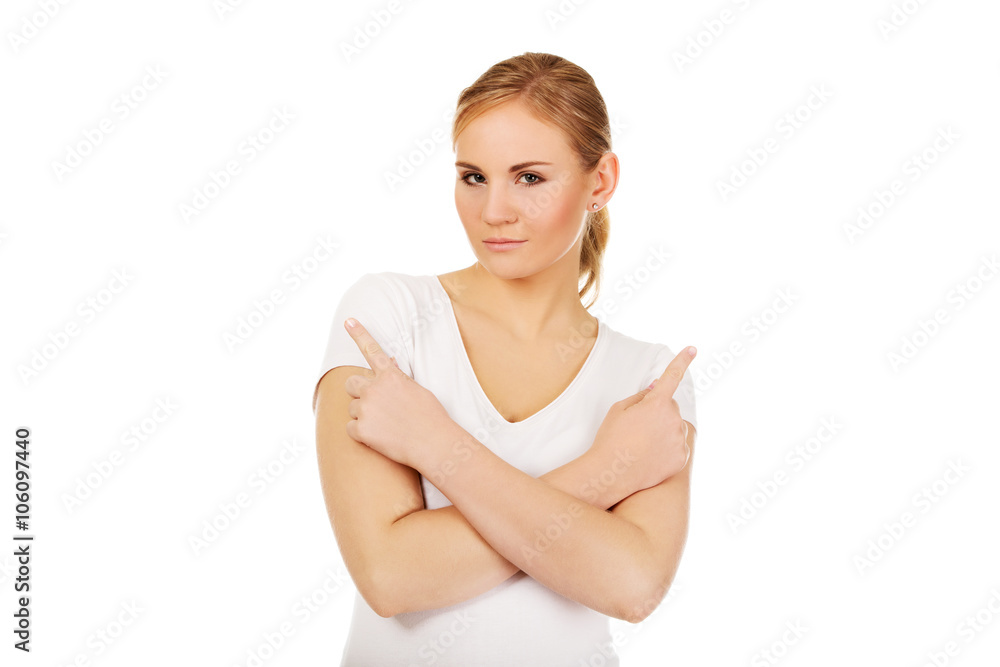 Confused young woman pointing in two different directions Confused young woman pointing in two different directions