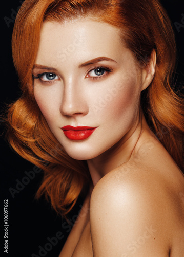 Portrait of a young woman with red hair and blue eyes.