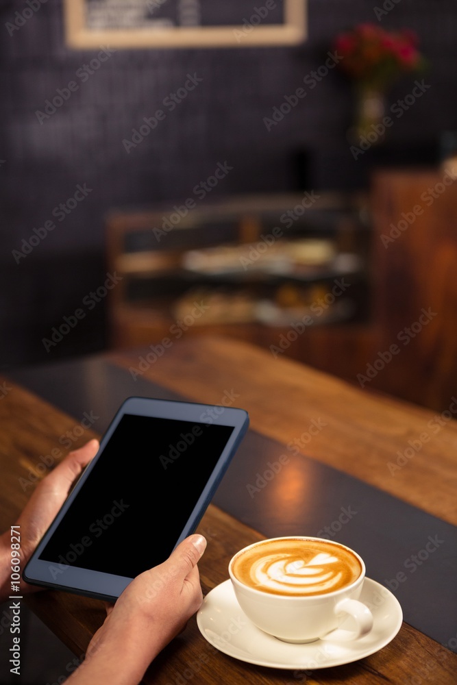 Woman drinking coffee and using tablet Woman drinking coffee and using tablet