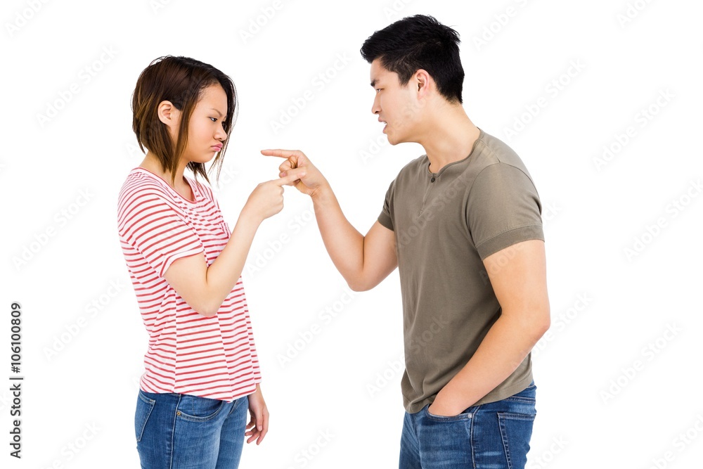 Young couple pointing at each other while having an argument Young couple pointing at each other while having an argument