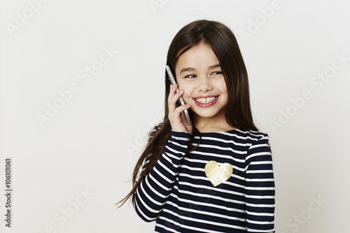 Smiling girl on cell phone, looking away