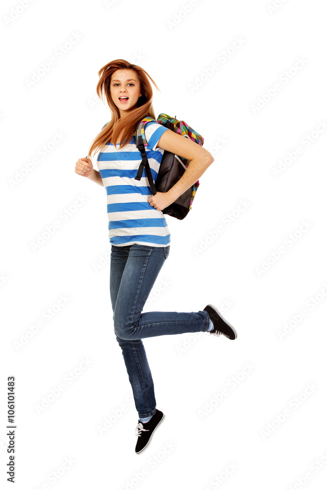 Teenage woman with backpack jumping 