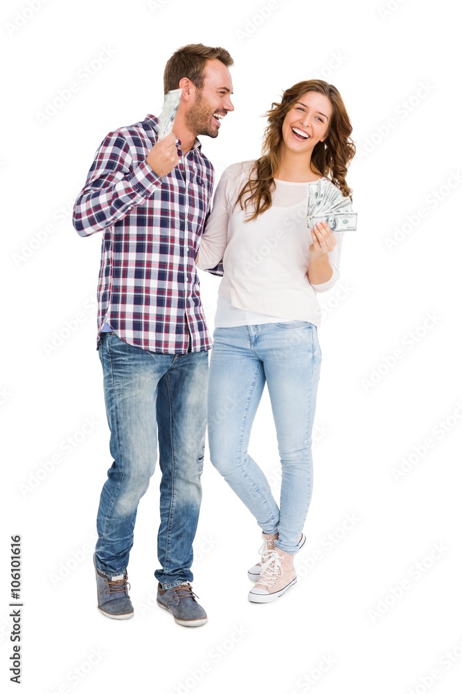 Happy young couple holding fanned out currency notes