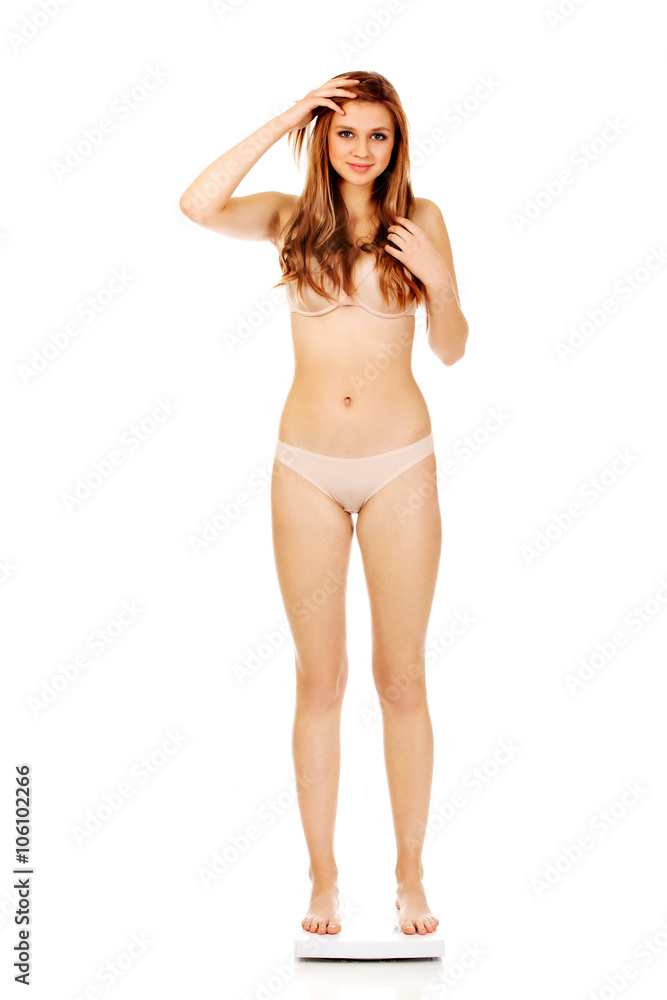 Young woman in underwear standing on scales Young woman in underwear standing on scales