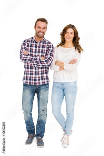 Happy couple standing with arms crossed