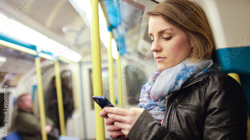 Attractive woman reading something on her phone on a subway train