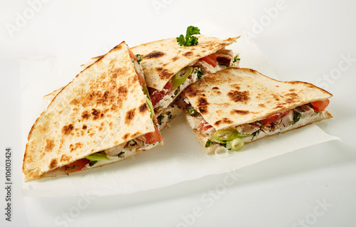Four quesadilla parts on wax paper photo