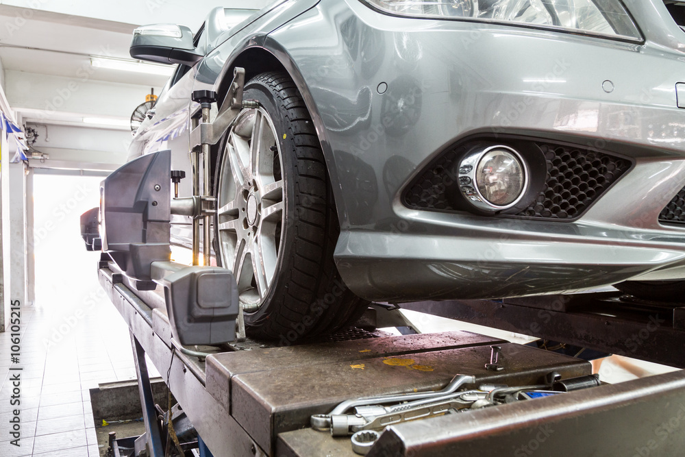 Obraz premium Closeup of tire clamped with aligner undergoing auto wheel align