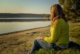 Kobieta siedząca nad jeziorem