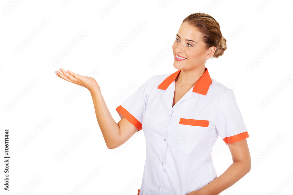 Smiling female doctor or nurse pointing at something Smiling female doctor or nurse pointing at something