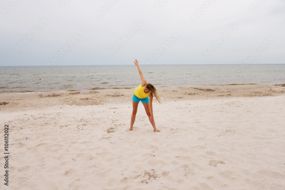 Young woman making yoga exercises on the beach Young woman making yoga exercises on the beach