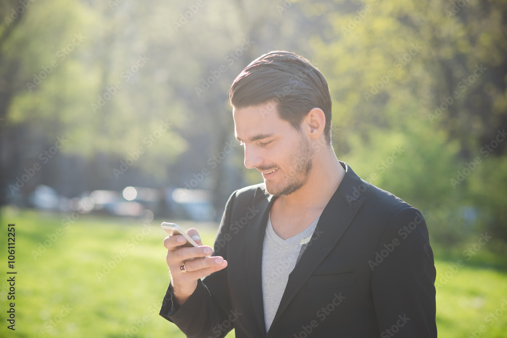 Portrait of a young handsome caucasian man using a smart phone c Portrait of a young handsome caucasian man using a smart phone c