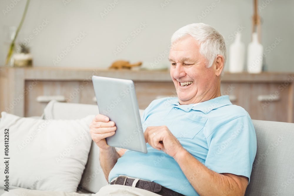 Happy senior man using digital tablet