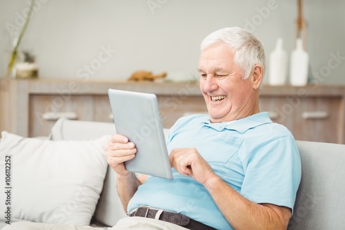 Happy senior man using digital tablet