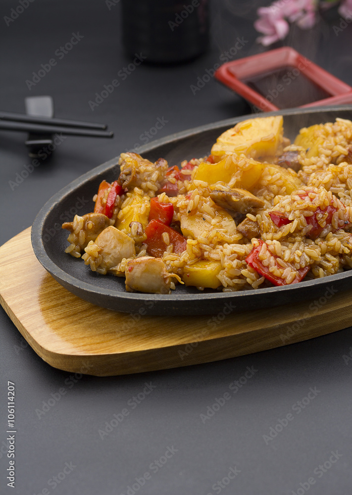 Asian rice with meat and pineapple over black background