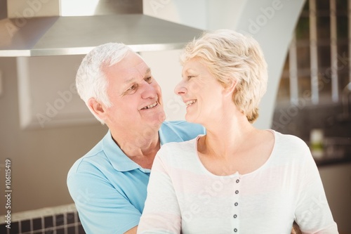 Active senior couple embracing in kitchen