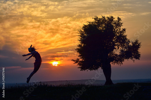young happy woman on field in summer sunset