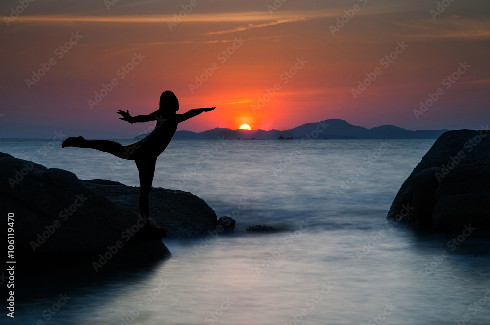 Silhouette of a beautiful yoga woman at sunset