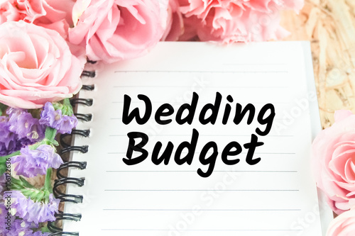 word wedding budget on note paper pink flower background