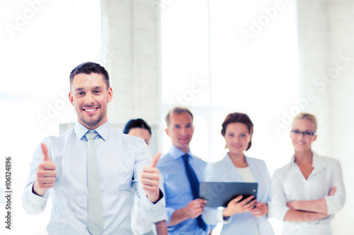 businessman in office showign thumbs up
