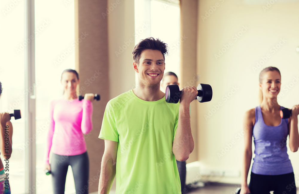 group of smiling people working out with dumbbells group of smiling people working out with dumbbells