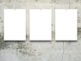 Close-up of three nailed blank frames on cracked and scratched wall background