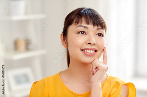 happy asian young dreaming woman face at home