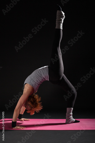 Young woman practicing yoga, Setuasana / variation of Bridge pose