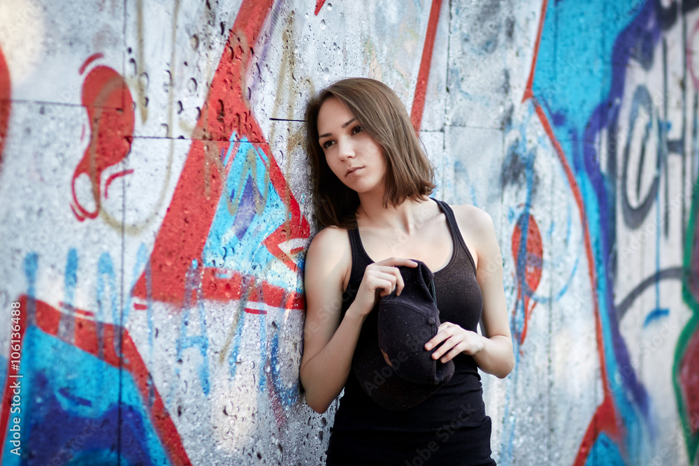 Naklejka premium Young girl on graffiti background