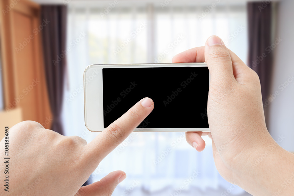 Female hand touching smartphone in her room