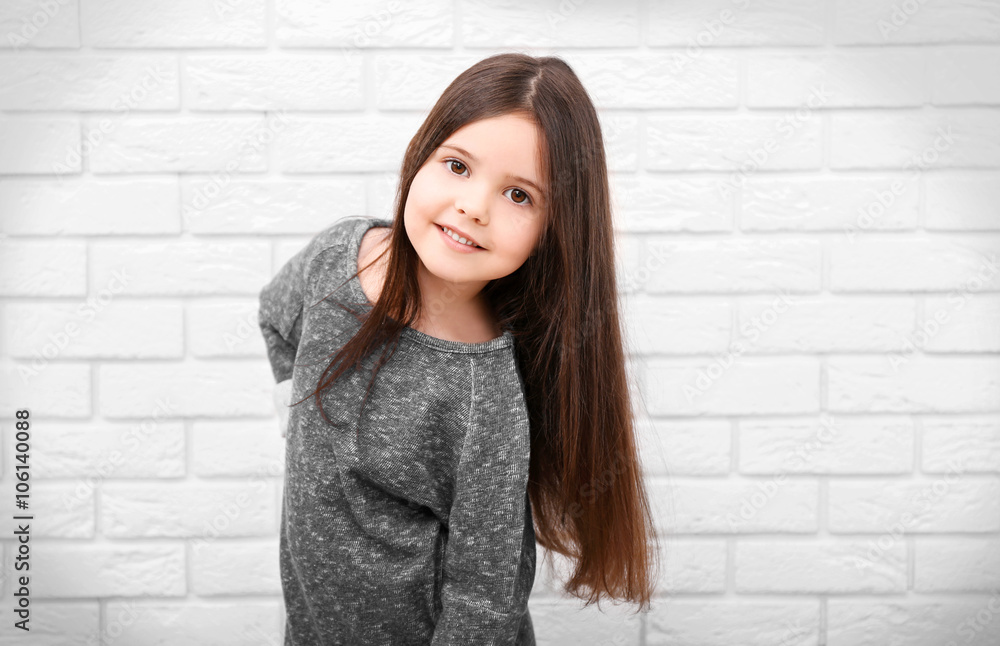 Little girl on a white brick wall background Little girl on a white brick wall background