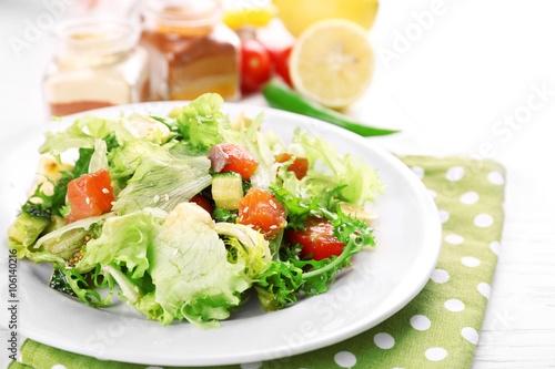 Tasty salmon salad on light wooden background