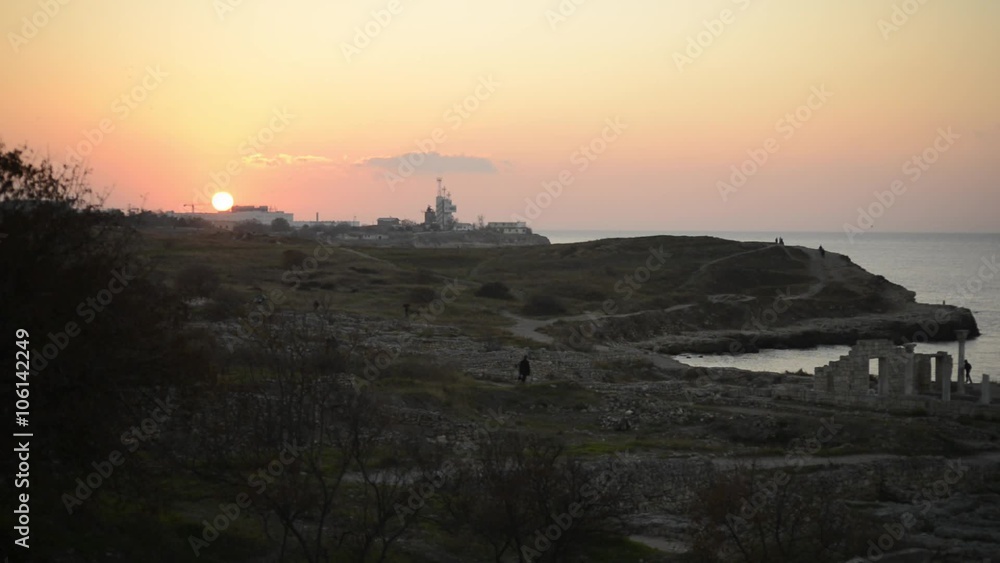 at Sunset, a Few People Move Around the Ancient Ruins on the Seashore at Sunset, a Few People Move Around the Ancient Ruins on the Seashore