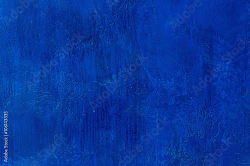 Old scratched and chapped painted royal blue wall. Abstract textured colored background, empty template