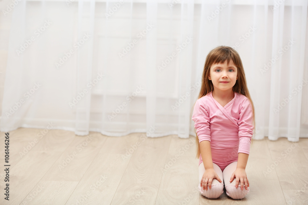 Little cute girl in pink leotard sitting on floor at dance studio Little cute girl in pink leotard sitting on floor at dance studio