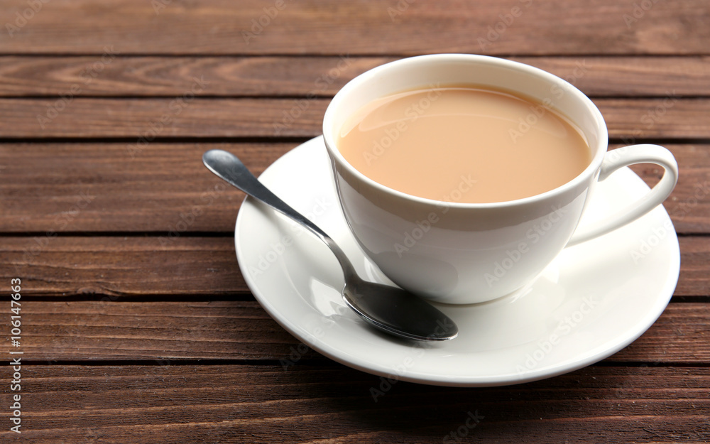 Porcelain cup of tea with milk on wooden background Porcelain cup of tea with milk on wooden background