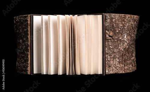 Tree and Book. Conceptual image about the cross section of the tree trunk and book on black background. 