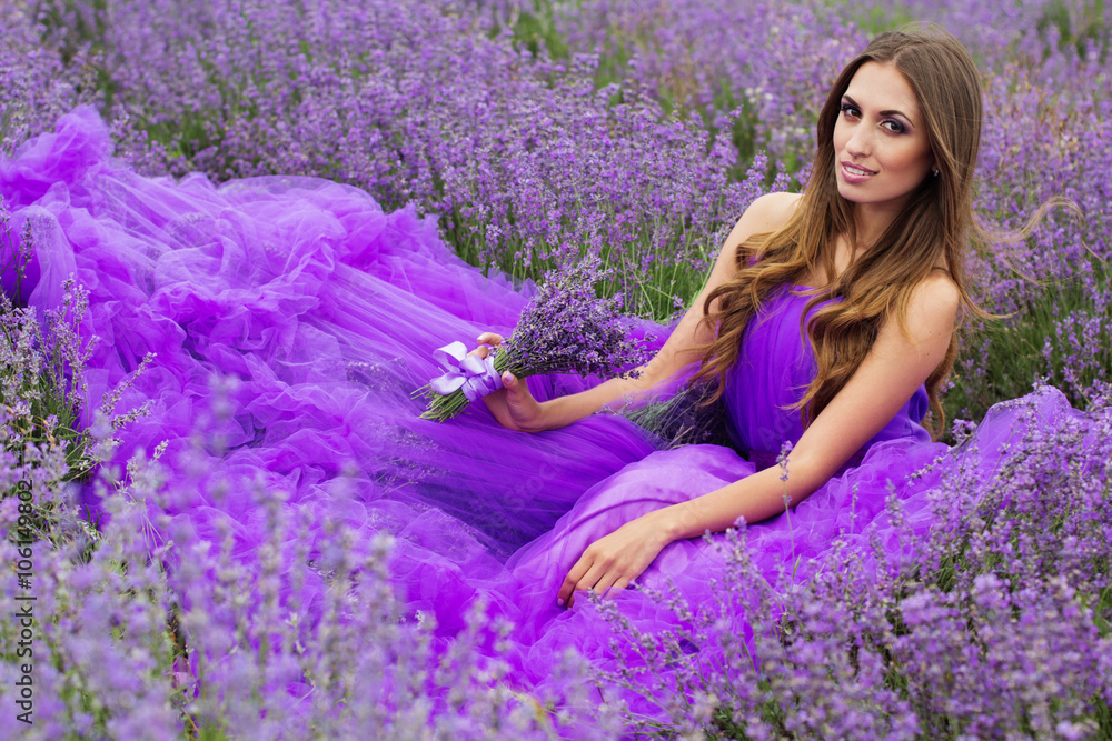 Pretty smiling girl is sitting in lavender field Pretty smiling girl is sitting in lavender field