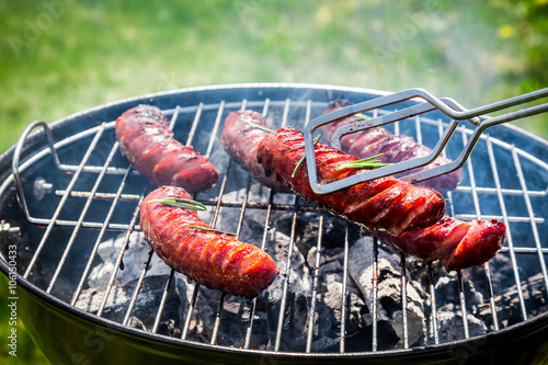Spicy sausages with spices and rosemary on garden grill