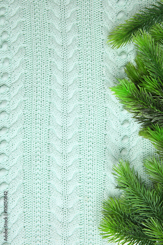 Fir twigs on knitted pattern background © Africa Studio