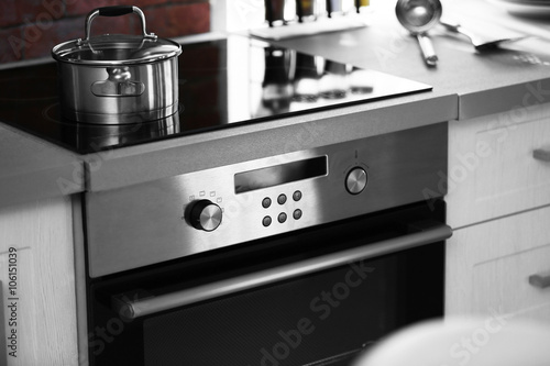Modern electric stove with utensils in the kitchen photo