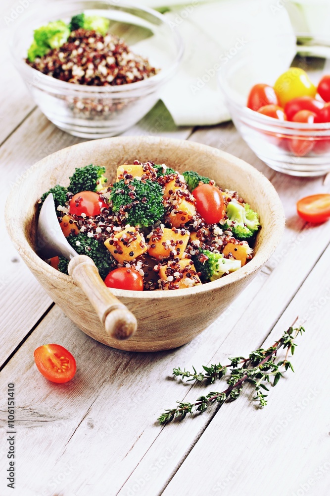 Quinoa salad with broccoli,sweet potatoes and tomatoes on a rustic wooden table.Superfoods concept.Selective focus. Quinoa salad with broccoli,sweet potatoes and tomatoes on a rustic wooden table.Superfoods concept.Selective focus.