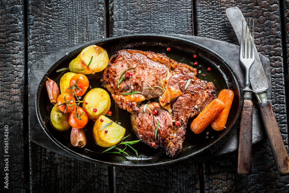 Roasted vegetables and steak with fresh herbs on grill Roasted vegetables and steak with fresh herbs on grill