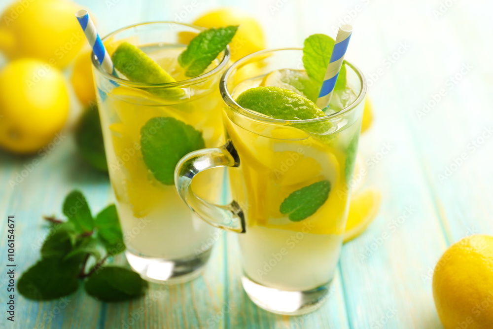 Composition of lemonades, lemons and mint on blue wooden table background Composition of lemonades, lemons and mint on blue wooden table background