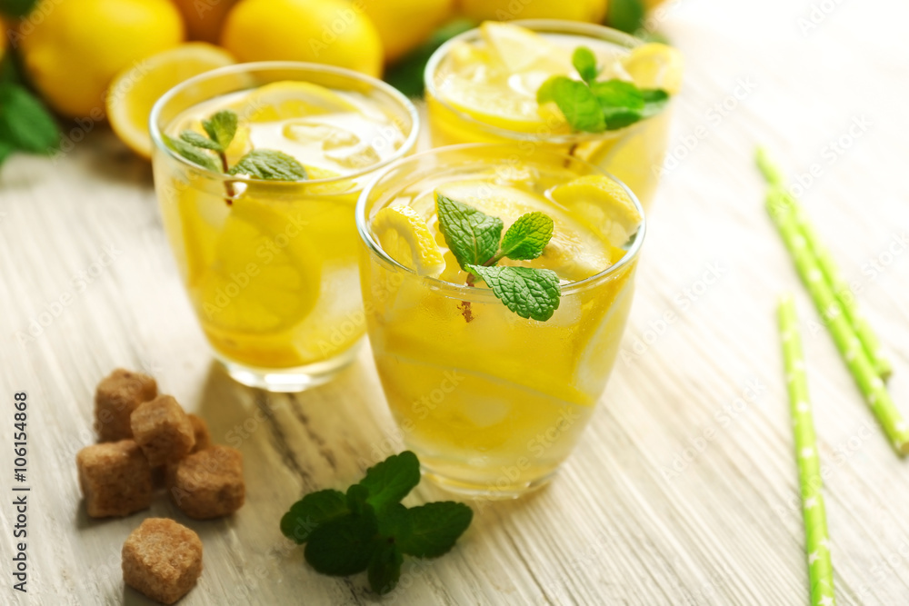 Fototapeta premium Composition of lemonades with lemons and mint on white wooden table background, closeup