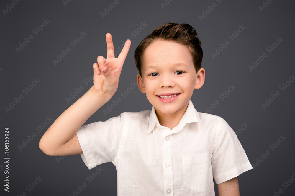 Little happy funny boy gesturing with two fingers Little happy funny boy gesturing with two fingers